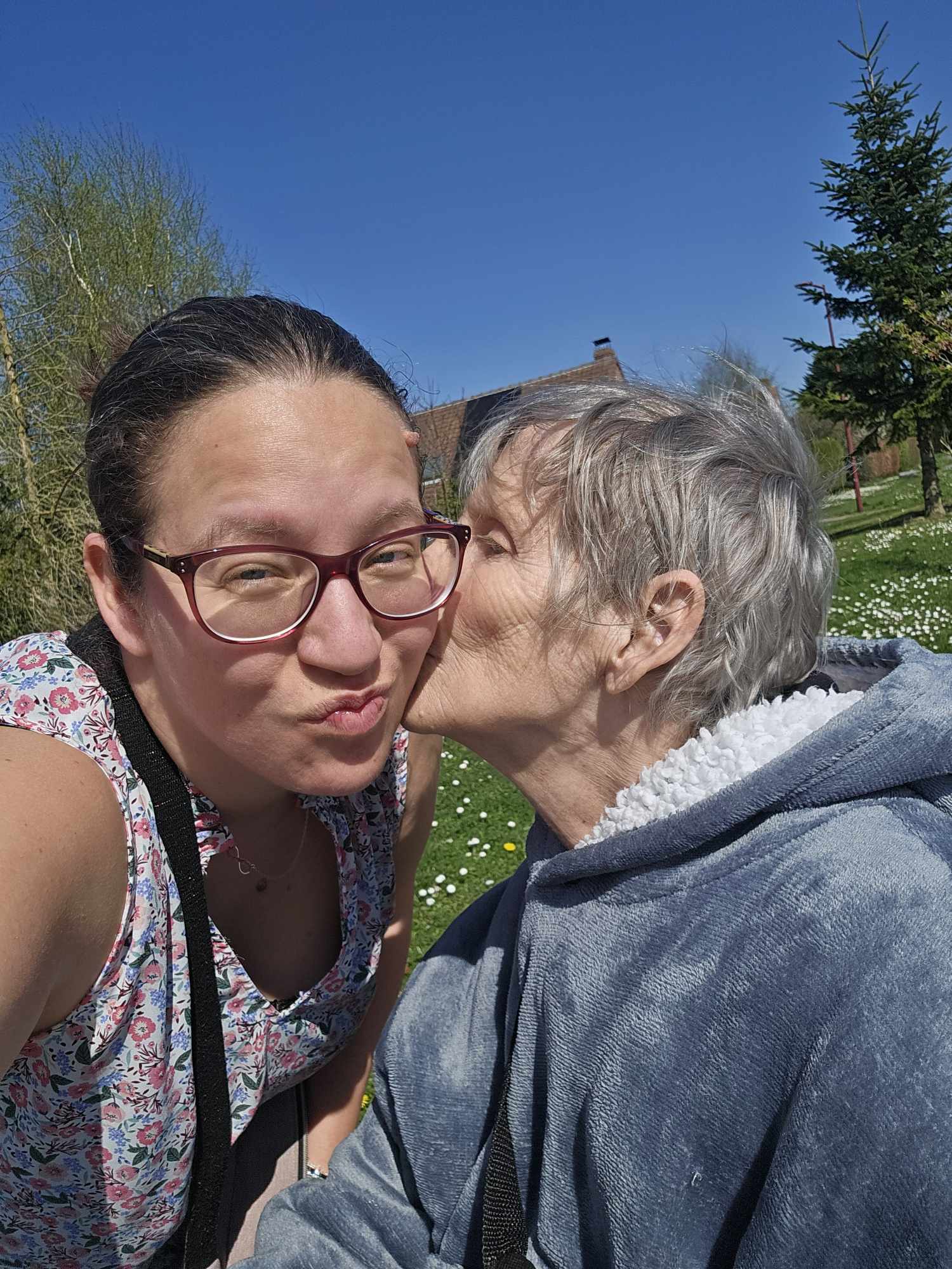 Grégorine embrasse sa maman Marie-Ange sur la joue lors d'une journée ensoleillée