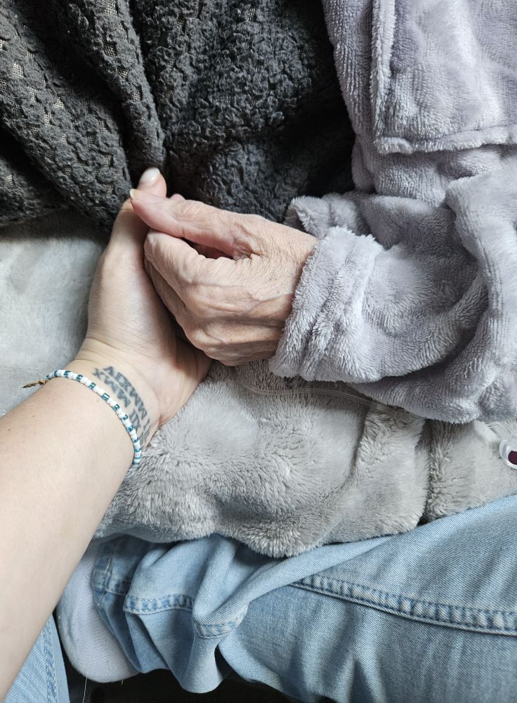 Main de Grégorine tenant celle de sa maman Marie-Ange en fin de vie